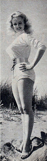 Sabrina at the beach in her belt and shorts
